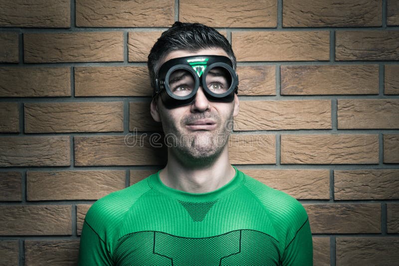 Terrified green superhero looking away and leaning to a wall. Terrified green superhero looking away and leaning to a wall.