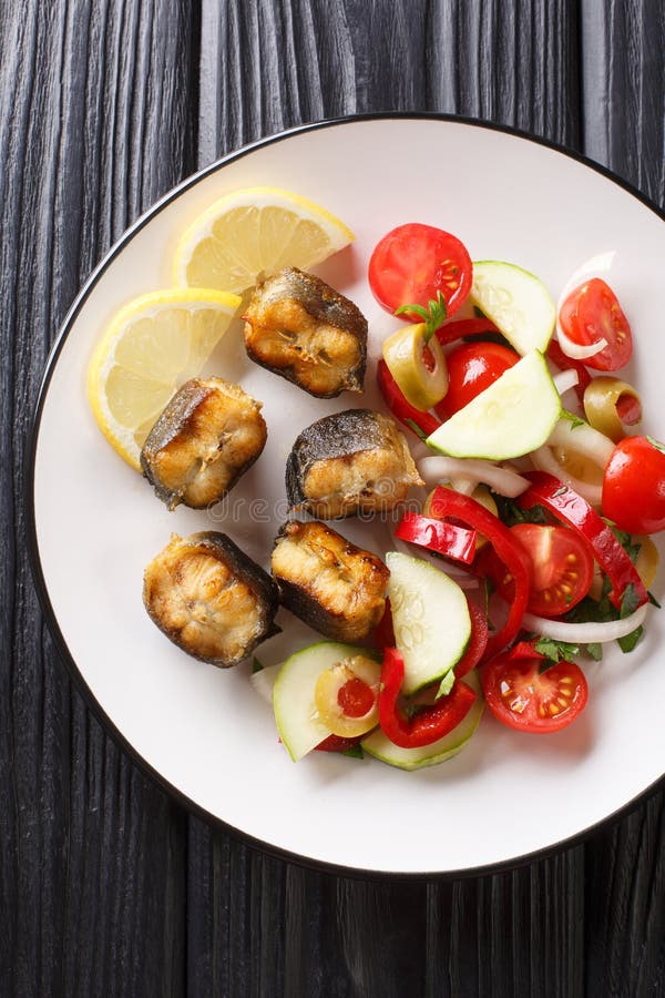 Anguila frita de la comida gastrónoma con el primer de la ensalada de las verduras frescas en una placa Visi?n superior vertical imagenes de archivo Anguila frita de la comida gastrónoma con el primer de la ensalada de las verduras frescas en una placa Visi?n superior vertical imagenes de archivo