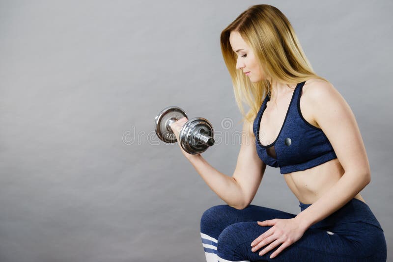 Anhebende Dummkopfgewichte der geeigneten Frau lizenzfreies stockbild Anhebende Dummkopfgewichte der geeigneten Frau lizenzfreies stockbild