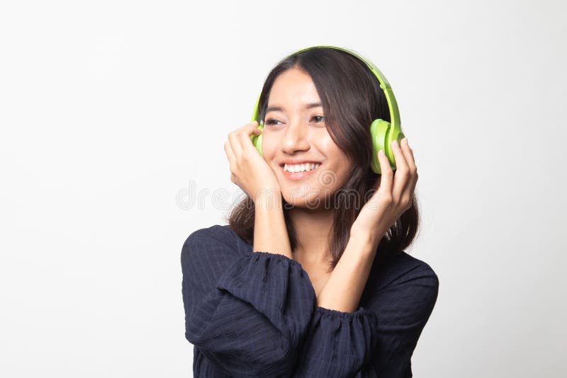 Anhörung Musik des hübschen asiatischen Mädchens mit ihren Kopfhörern stockbild