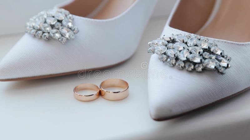 Anillos de boda y zapatos de novia. dos símbolos matrimoniales. el amor de la novia y el novio por convertirse en esposa y marido.