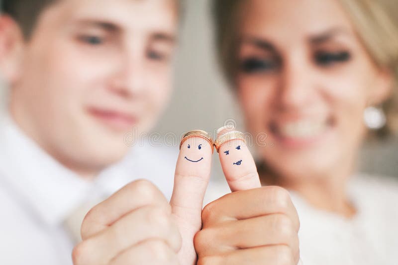 Anillos de bodas en sus fingeres pintados con la novia y el novio imagen de archivo Anillos de bodas en sus fingeres pintados con la novia y el novio imagen de archivo