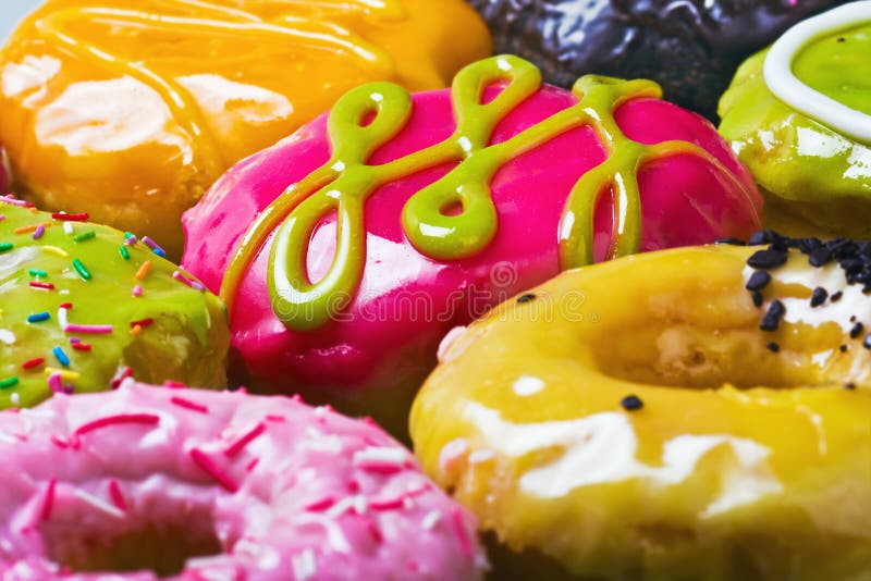 Glazed donuts in the range of background. Focus on the pink donut. Glazed donuts in the range of background. Focus on the pink donut.