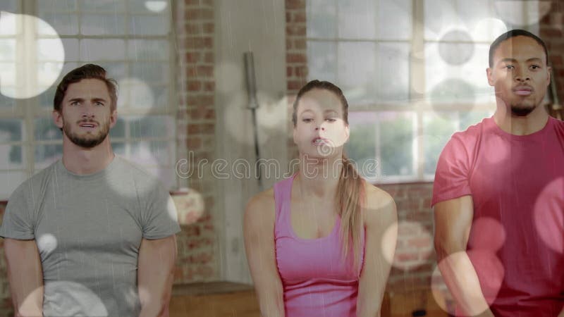 Animación de lentes flares sobre amigos multirraciales haciendo ejercicio con campanas de cetáceos en el gimnasio almacen de video