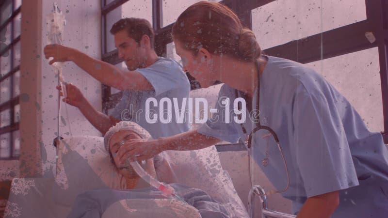 Animation d'un mot covid19 clignotement au-dessus des médecins en marchant avec un lit avec un patient dessus banque de vidéos