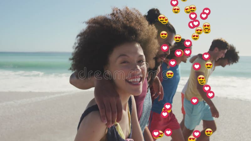 Animation de coeurs et d'amour émoticônes sur divers groupes d'amis heureux marchant sur la plage ensoleillée banque de vidéos