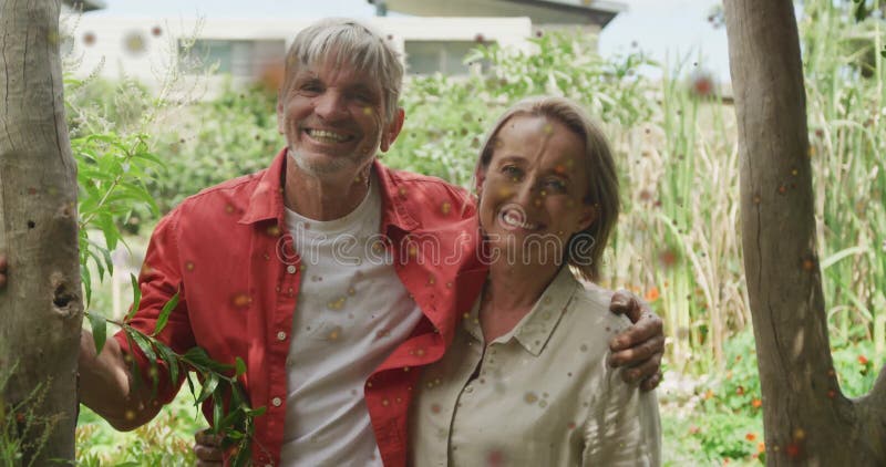Animation de taches rouges sur un couple de caucasiens heureux embrassant dans le jardin banque de vidéos