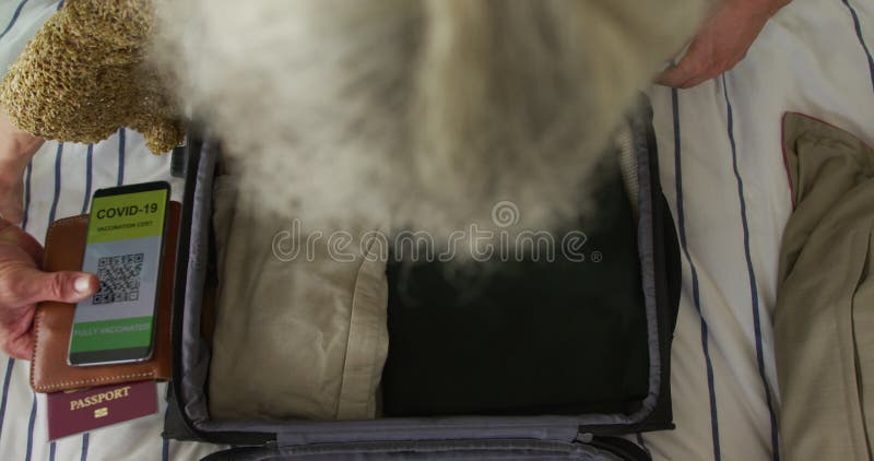 Animation des mains de caucasian senior couple emballage covid vaccinez passeport dans valise banque de vidéos