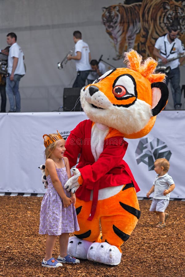 Animator in a tiger suit playing with children.