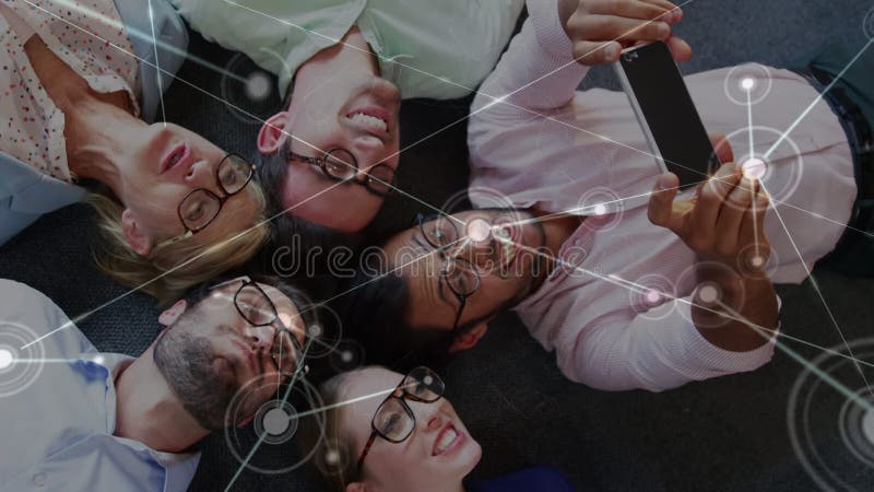 Animazione dei punti che si connettono con le linee sull'uomo che si fa selfie con i colleghi che si sdraia sul pavimento video d archivio