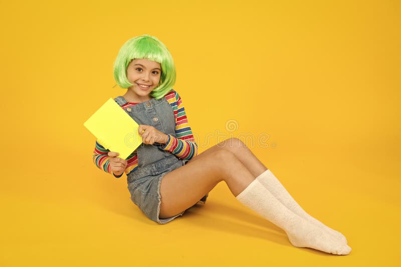 Anime comics. Comics store. Anime fan. Cheerful kid in bright colorful wig. Cosplay party concept. Happy childhood royalty free stock photo