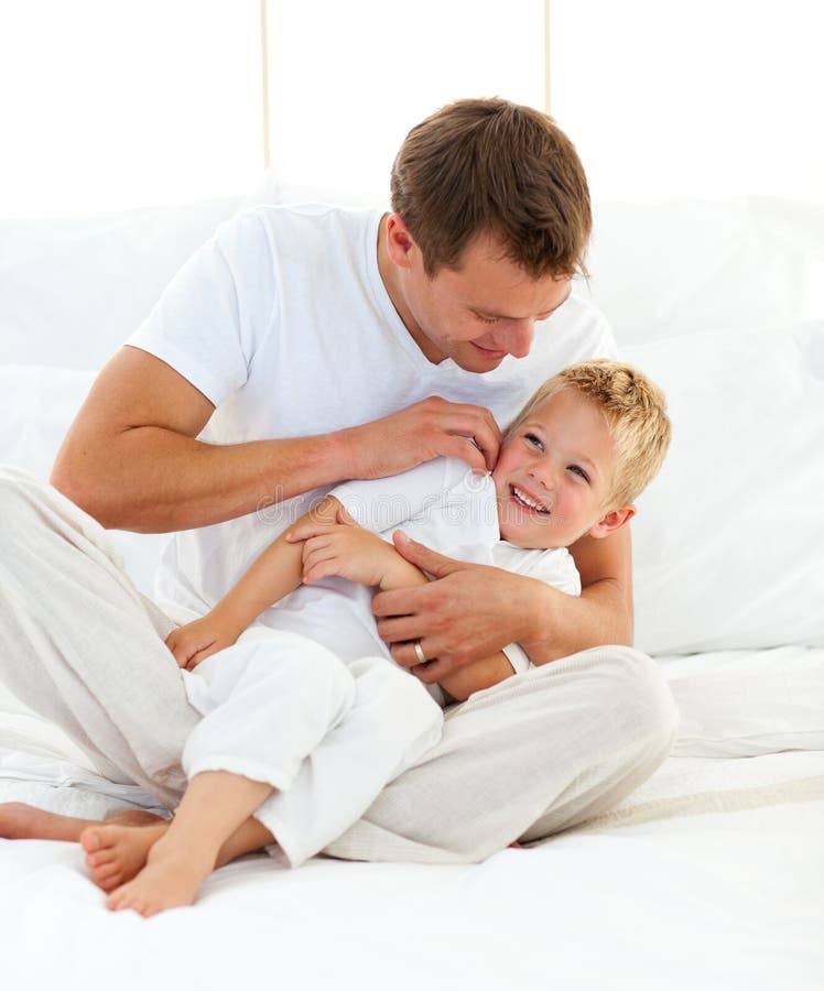 Animated little boy having fun with his dad on a bed. Animated little boy having fun with his dad on a bed