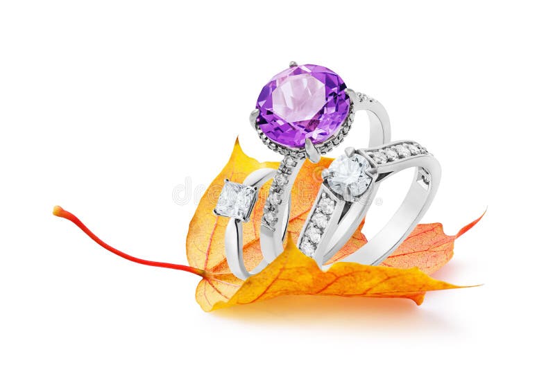 Anneaux d'or sur une feuille d'automne d'isolement sur le fond blanc Concept sur le thème des remises saisonnières de bijoux photos libres de droits Anneaux d'or sur une feuille d'automne d'isolement sur le fond blanc Concept sur le thème des remises saisonnières de bijoux photos libres de droits