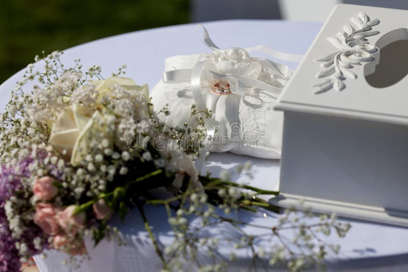 Anneaux de mariage d'or sur le coussin extérieur image stock Anneaux de mariage d'or sur le coussin extérieur image stock