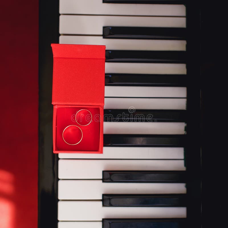 Anneaux de mariage dans la boîte rouge sur le piano photographie stock libre de droits Anneaux de mariage dans la boîte rouge sur le piano photographie stock libre de droits