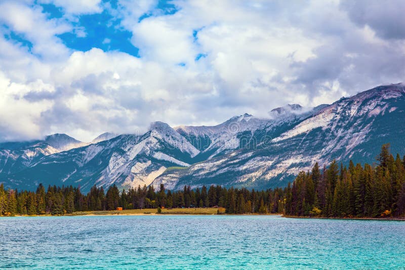 The Rocky Mountains of Canada. Indian summer. Annette Lake - lovely lake with cold green water.  Magnificent landscape in Jasper Park. Travel and photo tourism concept. The Rocky Mountains of Canada. Indian summer. Annette Lake - lovely lake with cold green water.  Magnificent landscape in Jasper Park. Travel and photo tourism concept