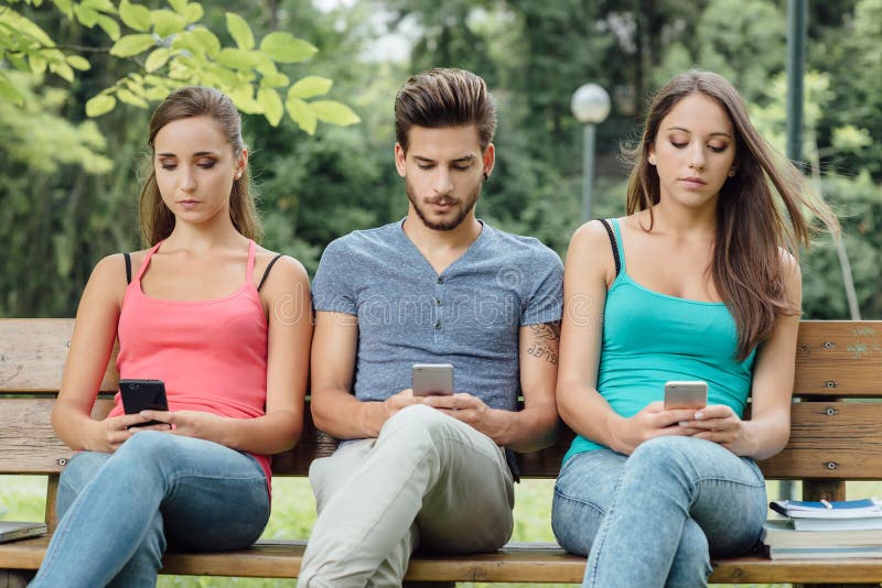 Anni Dell Adolescenza Al Parco Facendo Uso Degli Smart Phone Immagine