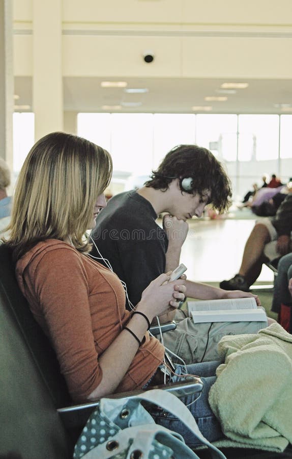Anni dell'adolescenza aspettanti dell'aeroporto fotografia stock libera da diritti Anni dell'adolescenza aspettanti dell'aeroporto fotografia stock libera da diritti