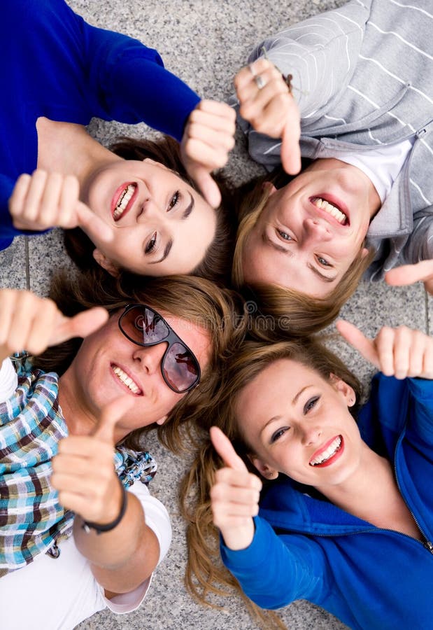 Anni dell'adolescenza con i pollici in su fotografie stock libere da diritti Anni dell'adolescenza con i pollici in su fotografie stock libere da diritti