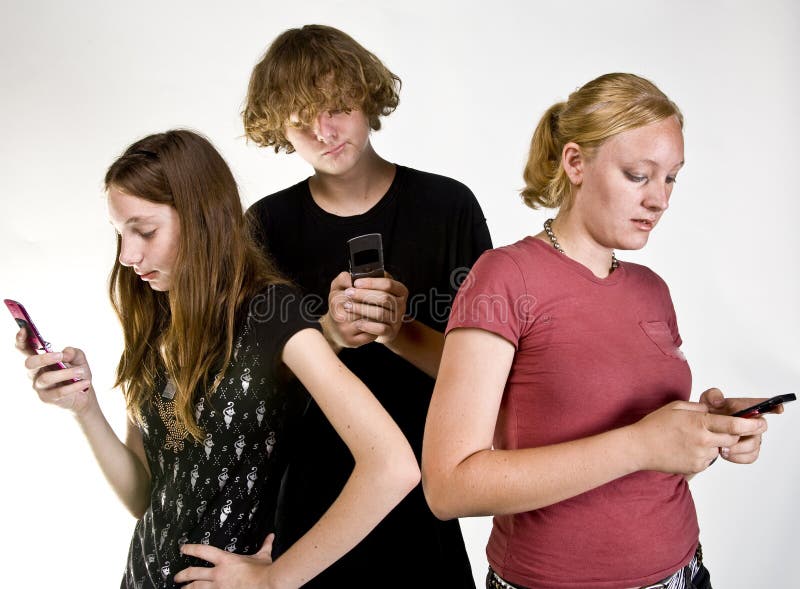 Adolescenti che mandano messaggi al cellulare fotografia stock libera da diritti