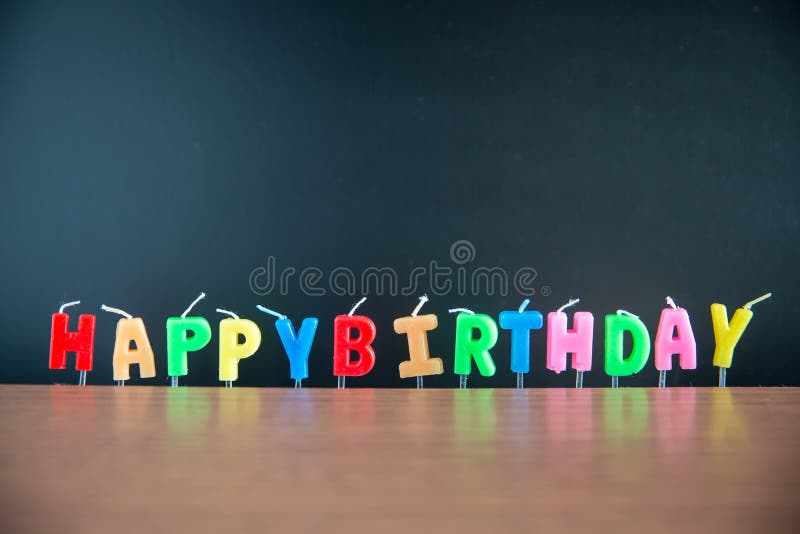 Anniversaire de mot d'alphabet de chandelier joyeux avec le tableau noir sur le plancher en bois photos stock Anniversaire de mot d'alphabet de chandelier joyeux avec le tableau noir sur le plancher en bois photos stock