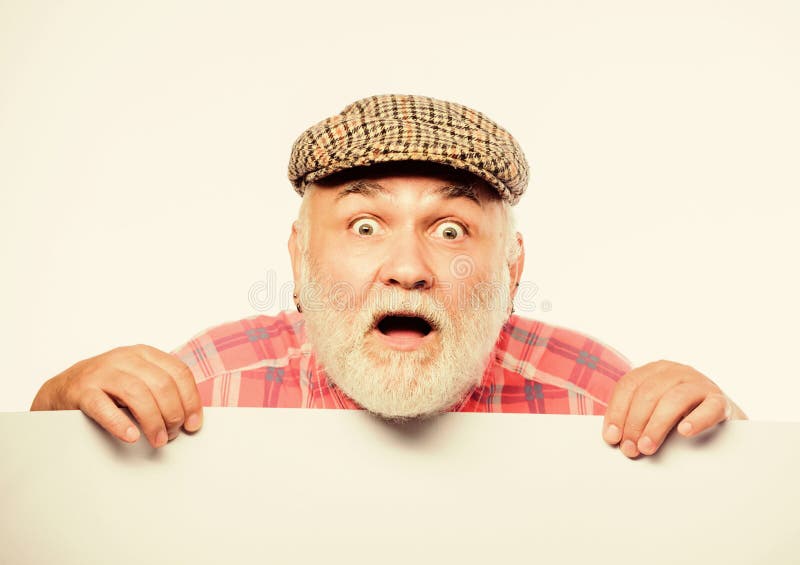 Announcement concept. Event announcement. Senior bearded emotional man peek out of banner place announcement. Pensioner stock photography Announcement concept. Event announcement. Senior bearded emotional man peek out of banner place announcement. Pensioner stock photography