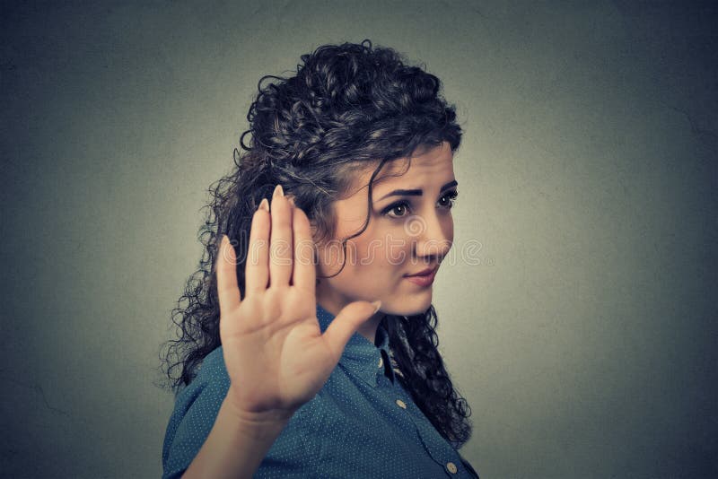 Closeup portrait young annoyed angry woman with bad attitude giving talk to hand gesture with palm outward isolated grey wall background. Negative human emotion face expression feeling body language