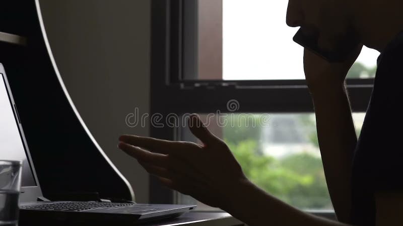 Annoyed freelancer talking phone and working at online project, deadline stress