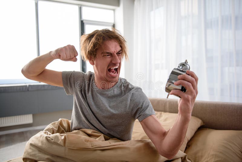 annoyed-man-waking-up-alarm-bedroom-feeling-furious-waist-portrait-angry-guy-sitting-bed-morning-waving-his-107754032.jpg