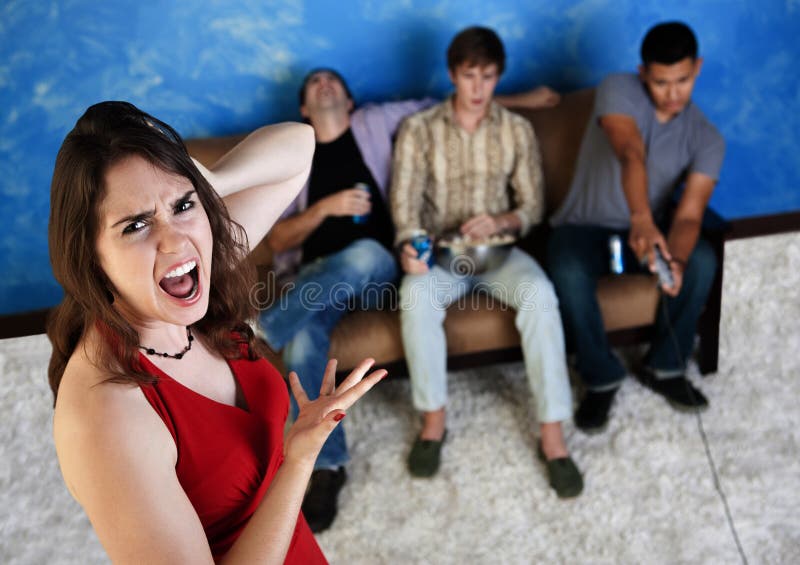 Caucasian women annoyed with three men playing video games. Caucasian women annoyed with three men playing video games