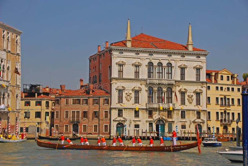 A group of elderly boat rowers with a very long boat taking a rest during the Vogalonga Regatta festival in Venice, Italy