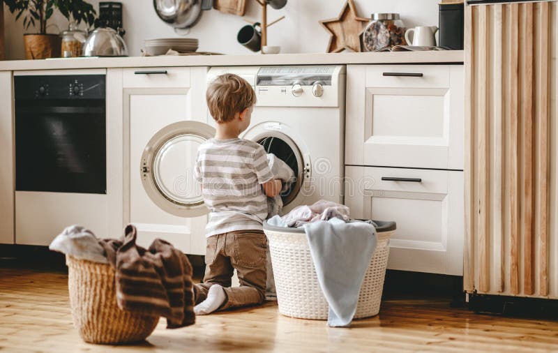 Anonymer Haushaltsvorstandkinderjunge in der Wäsche mit Waschmaschine lizenzfreies stockbild