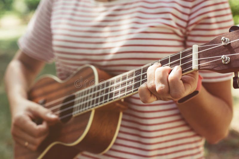 Anonymous woman playing ukulele stock images