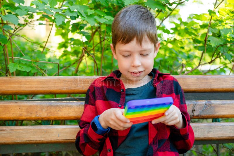 8ans Garçon Jouant Avec Popit Dans Le Parc. Enfant Heureux Avec Jouet.  Enfant Portant Des Vêtements Décontractés D'été Lumineux Image stock -  Image du lumineux, pièce: 220045359