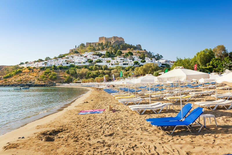 Ansicht des sandigen Strandes in der Bucht von Lindos, Akropolis in Hintergrund R stockbilder Ansicht des sandigen Strandes in der Bucht von Lindos, Akropolis in Hintergrund R stockbilder
