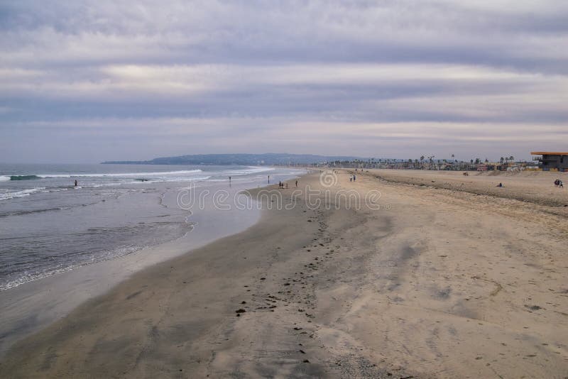 View from Mission Beach in San Diego, of Piers, Jetty and sand, around surfers, including warning signs, palm trees, waves, rocks, boats and horizon views. Pacific Ocean. California, United States. View from Mission Beach in San Diego, of Piers, Jetty and sand, around surfers, including warning signs, palm trees, waves, rocks, boats and horizon views. Pacific Ocean. California, United States.