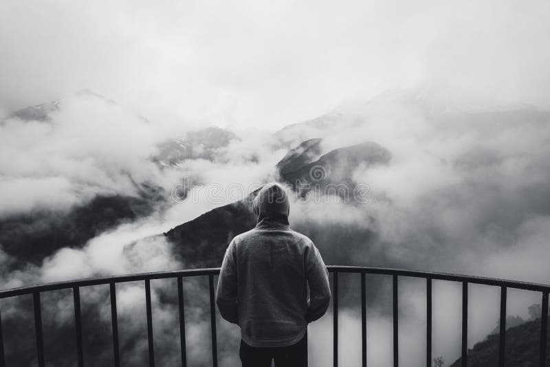 Ansicht von hinten eines Mannes, der am Standpunkt schaut zur schönen Landschaft mit nebeligen Bergen im Abstand steht Schwarzes lizenzfreies stockfoto Ansicht von hinten eines Mannes, der am Standpunkt schaut zur schönen Landschaft mit nebeligen Bergen im Abstand steht Schwarzes lizenzfreies stockfoto
