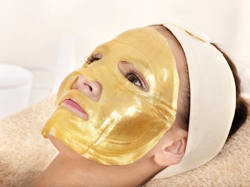 Young womanl with gold facial mask. Young womanl with gold facial mask.