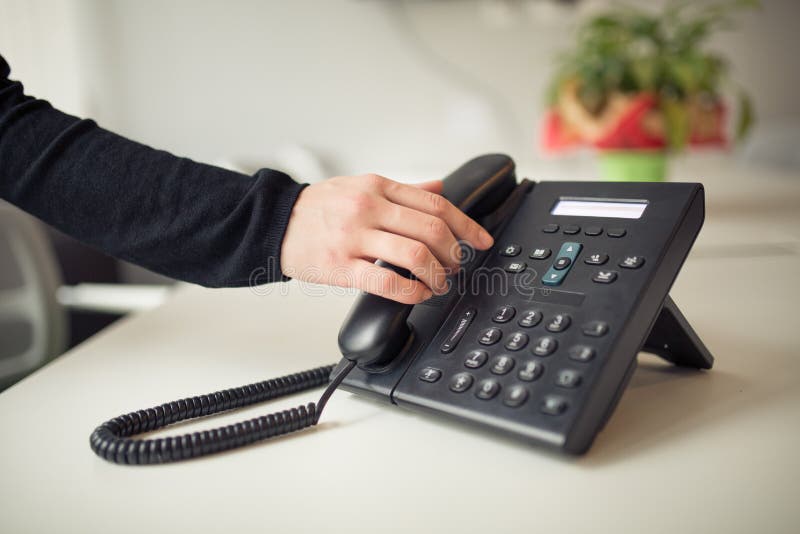 Answering phone call.Phone ringing.Good or bad news.Business failure.Customer service help center.Secretary answering phone in her office.Desk table office phone and womans hand picking up