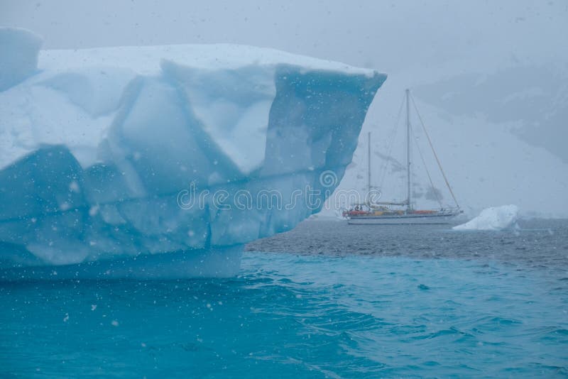 Antarktis unikt ojämnt blått strimmigt isberg med segelbåten royaltyfri fotografi Antarktis unikt ojämnt blått strimmigt isberg med segelbåten royaltyfri fotografi