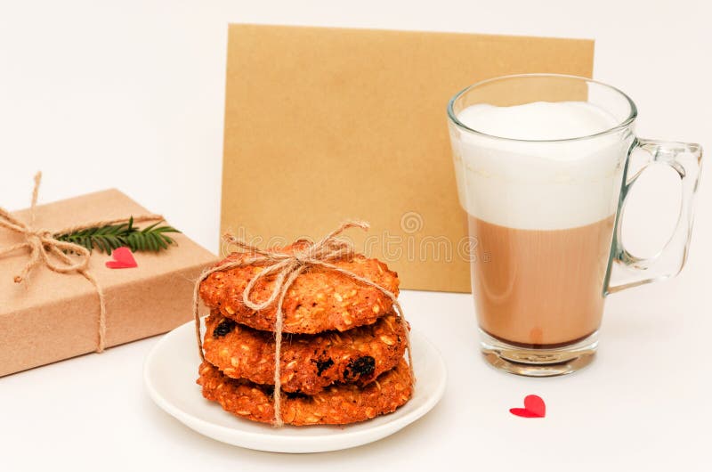 Antecedentes del día de San Valentín Galletas caseras de avena, jarra transparente de capuchino, caja de regalo, tarjeta en blanc foto de archivo libre de regalías Antecedentes del día de San Valentín Galletas caseras de avena, jarra transparente de capuchino, caja de regalo, tarjeta en blanc foto de archivo libre de regalías