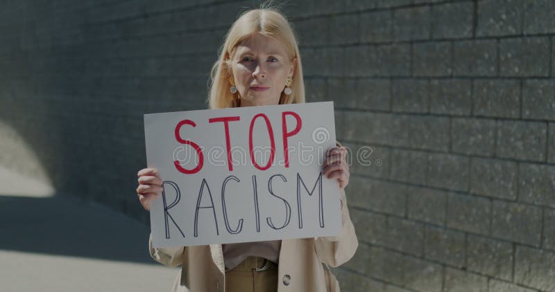 Anteckning av mogen kvinna som höjer rasismen och protesterar mot rasorättvisor i staden på soliga dagar