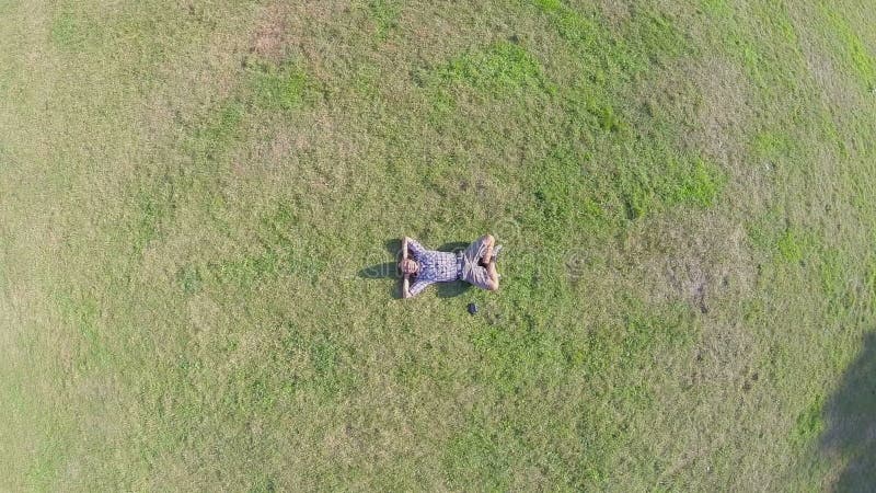 Antena, młody pozytywny mężczyzna lying on the beach na ziemi rękach za głową