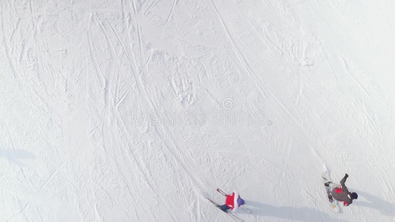 Antenne van skiër en snowboarder het glijden onderaan sneeuwhelling met exemplaar en beschikbare ruimte