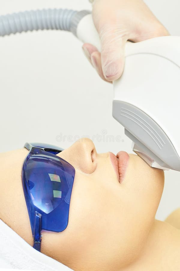 Anti acne removal procedure. Cosmetology device. Woman facial tightening clinic. Beautiful girl and doctor hand