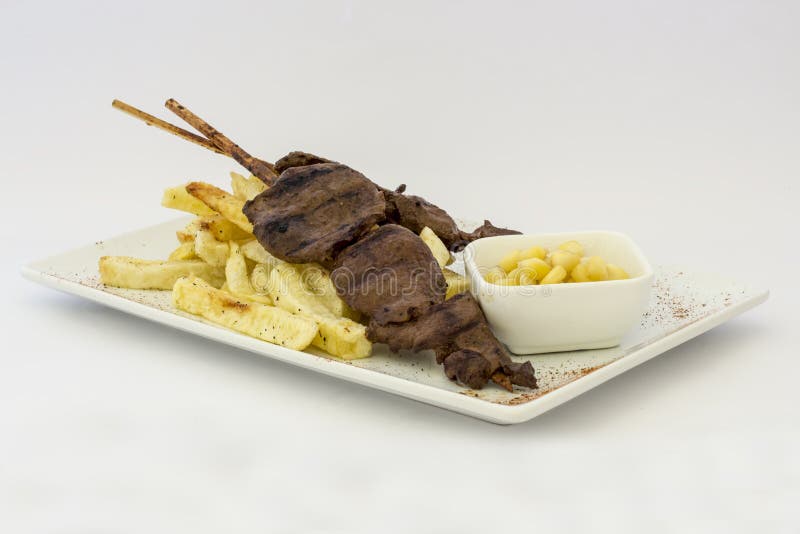 Anticuchos, cuisine péruvienne, brochettes de viande grillées de coeur de boeuf avec des pommes de terre de fritures (pommes frit photographie stock Anticuchos, cuisine péruvienne, brochettes de viande grillées de coeur de boeuf avec des pommes de terre de fritures (pommes frit photographie stock