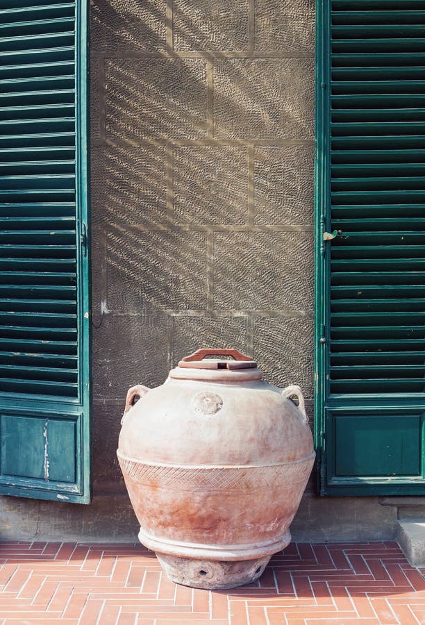 Antieke kleikruik die zich door de muur van een oud huis in Italië bevinden royalty-vrije stock afbeelding Antieke kleikruik die zich door de muur van een oud huis in Italië bevinden royalty-vrije stock afbeelding