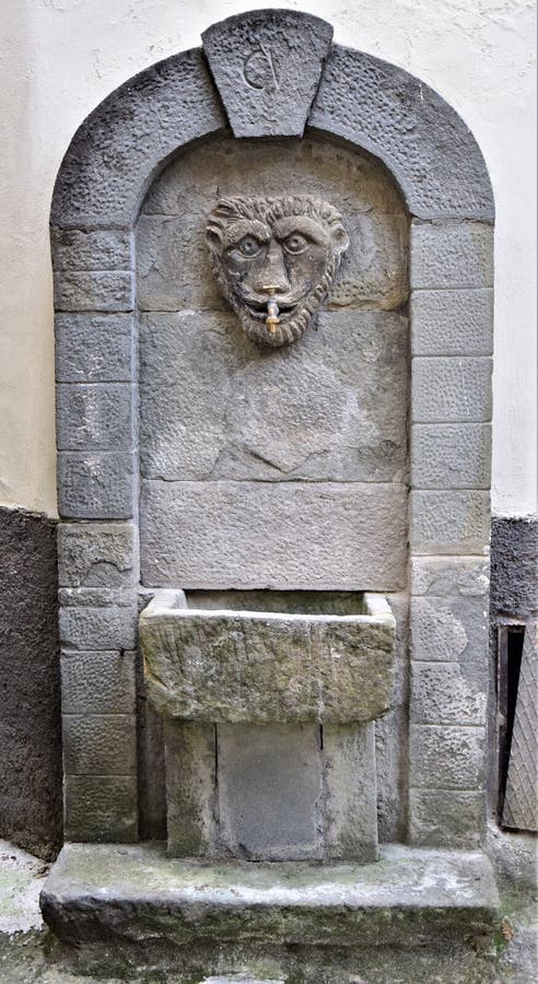 Antigua fuente con arco y cabeza construida en piedra en Vergemoli