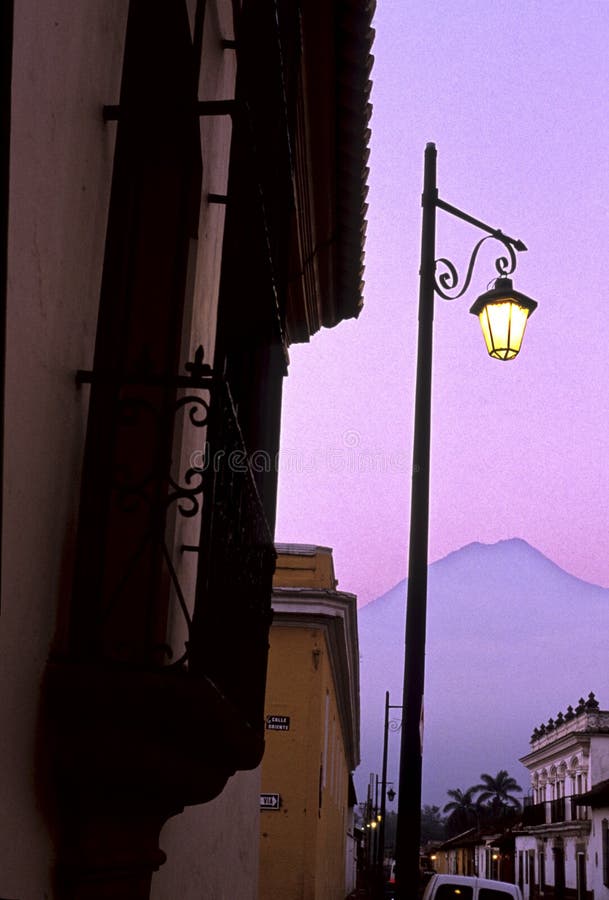 Volcan Fuego and streetlamp illuminated at dusk in the UNESCO World Heritage city of Antigua- Guatemala. Volcan Fuego and streetlamp illuminated at dusk in the UNESCO World Heritage city of Antigua- Guatemala