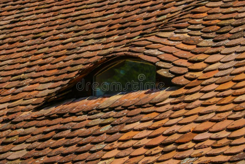 Antiguos tragaluces de las tejas rojas de una casa en la parte antigua de la ciudad imagen de archivo Antiguos tragaluces de las tejas rojas de una casa en la parte antigua de la ciudad imagen de archivo
